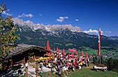 hikers on terrace of alpine hut Ruebezahlalm, view to Wilder Kaiser range, Hartkaser, Ellmau, Tyrol, Austria
