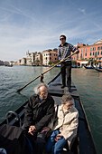 Gondolier on Gondola crossing Grand Canal near Rialto Bridge, Venice, Veneto, Italy