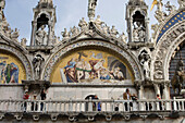 Mosaic and tourists on the balcony of St Mark's Basilica Cathedral on Piazza San Marco, Venice, Veneto, Italy