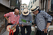 Drei Gondolieri, Gondelfahrer blicken auf Stadtplan, Venedig, Venetien, Italien, Europa