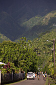 Menschen auf einer Strasse vor Kokosnuss Plantage, Omo’a, Fatu Hiva, Marquesas, Polynesien, Ozeanien