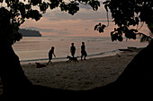 Kinder spielen am Strand von Lagune bei Sonnenuntrgang, Neu Irland, Papua Neuguinea