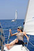 Sailing, woman sunbathing at the bow