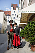 Münchner Paar in traditioneller Kleidung, Turm des Alten Hof im Hintergrund, München, Bayern, Deutschland