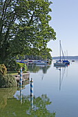 Boote ankern in Ufernähe auf dem Starnberger See, Tutzing, Bayern, Deutschland