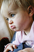 Headshot of 1 year old girl looking off camera, serious