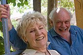 Retired couple sitting together smiling into camera