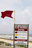 Surf conditions, warning flag and sign, Gulf Coast, sandy beach. Galveston, Texas