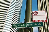 USA, Illinois, Chicago. Sign on Michigan Avenue point to Millennium Park bicycle station, Tow Zone, No Parking