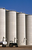 Rice storage silos and tractor. Sutter County, California. USA.