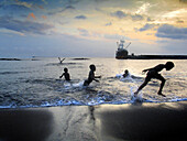 Children playing on beach by the port of Ipikel. Tanna, Vanuatu