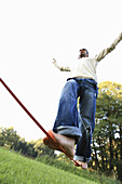 Young man balancing on rope, Irsee, Bavaria, Germany