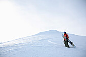 Snowboarder trägt Snowboard, Reutte, Tirol, Österreich