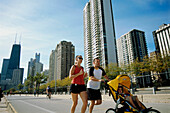 Young family jogging atOak Street Beach, Gold Coast, Chicago, Illinois,USA