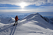 backcountry skiier on ridge with cornices and ski tracks, Kühgundkopf, Allgaeu range, Allgaeu, Tyrol, Austria