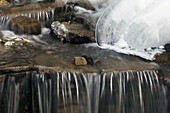 Ice formations and running water at O Shaughnessy Creek. Alberta, Canada