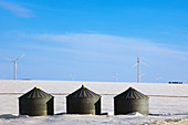 Wind Turbines on snowy prairie with grainery buildings. Manitoba, Canada 
