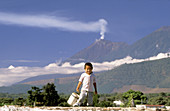 Mayan boy and the Volcán de Fuego in background. Antigua Guatemala. Guatemala