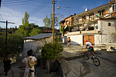 People cycling through Lemithou village, Troodos mountains, South Cyprus, Cyprus