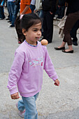 Little girl taking part in an egg and spoon race at the Easter games, Kathikas, South Cyprus, Cyprus