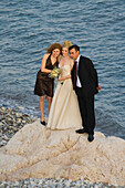 Bride and groom, bridal couple and bridesmaid on rocks at Petra tou Romiou, Rock of Aphrodite, Aphrodite's birthplace, Limassol, South Cyprus, Cyprus