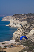 Paraglider over the steep rocky coast, Kourion, South Cyprus, Cyprus