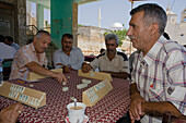 Local men sitting in a cafe playing a game, Kafenion, Dipkarpaz, Rizokarpaso, Karpasia, Karpass Peninsula, Cyprus