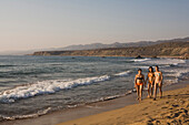 Three young women walking along the beach, Lara beach, Akamas nature parc, South Cyprus, Cyprus