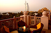 Outdoor Seating at restaurant terrace at dusk, Al Qasr hotel, View at Burj Al Arab Hotel, Madinat Jumeirah, Dubai, United Arab Emirates, UAE