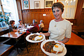 Kellnerin mit traditionellem Essen, Leberlis mit Rösti, Restaurant Hasenburg, Basel, Schweiz