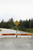 An English and French sign of a closed country road in Alberta, Canada