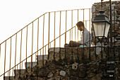 Man writing his journal on steps. Cannes, France