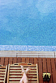 Woman relaxing on long chair near swimming pool at Hotel El Tio Kiko. San José. Cabo de Gata. Andalucia. Spain