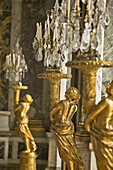 Golden statues holding lamps in the Hall of Mirrors. Chateau of Versailles. France