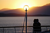 People walking on deck of a cruise ship at sunset. Alaska