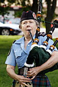 Portrait of Bag pipers playing music as they march in a parade