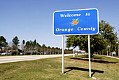 County road sign Welcoming Drivers to Orange County Kissimmee Orlando Disney Theme Park Area. Florida. USA