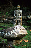Verwitterte Steinfiguren an einer archäologischen Stätte im Dorf Hatiheu auf der Insel Nuku Hiva, Französisch Polynesien