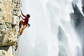 Frau, Barbara Raudner, beim Klettern in Maltatal, Wasserfall im Hintergrund, Maltatal, Fallbachfall, Nationalpark Hohe Tauern, Kärnten, Österreich