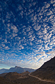 Mountain landscape with white clouds at sunrise, Sayh plateau, Hajjar mountains, Kashab, Khasab, Musandam, Oman