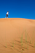 Woman walking on dune, Arabian Desert, United Arab Emirates