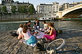 People relaxing on the banks of the river Seine, Paris, France, Europe