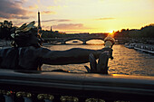 Figur an einer Brücke über der Seine bei Sonnenuntergang, Blick von Pont Alexandre III, Paris, Frankreich, Europa