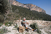 Wanderer bei der Rast auf Wanderpfad zum Castell d'Alaro, Alaro, Mallorca, Balearen, Spanien, Europa