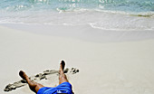 Man sunbathing at beach. Platja de Migjorn, North coast of Formentera, Balearic Islands. Spain