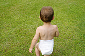 Toddler in diapers at garden