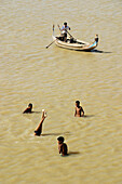 Boys playing and canoe. Thaungthaman Lake. Amarapura. Mandalay Division. Myanmar (Burma).