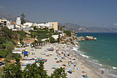 Salon beach, Balcón de Europa at background and the tower from the Church of Salvador (17th Century). Nerja. Malaga Province. Andalusia. Spain
