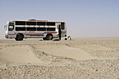 Bus on National Road 315. Taklamakan desert. Xinjiang Uyghur Autonomous Region. China.