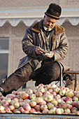 Uighur men sell apples at the Sunday Market. Kashgar (Kashi). Xinjiang Uyghur Autonomous Region. China.